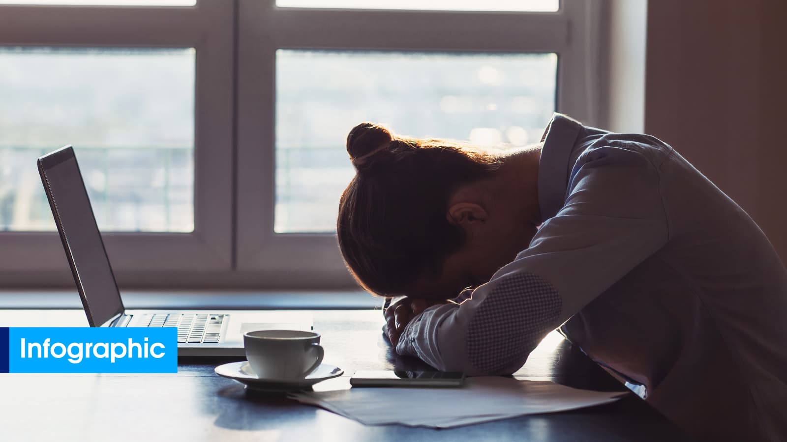 woman behind laptop resting on arms tired
