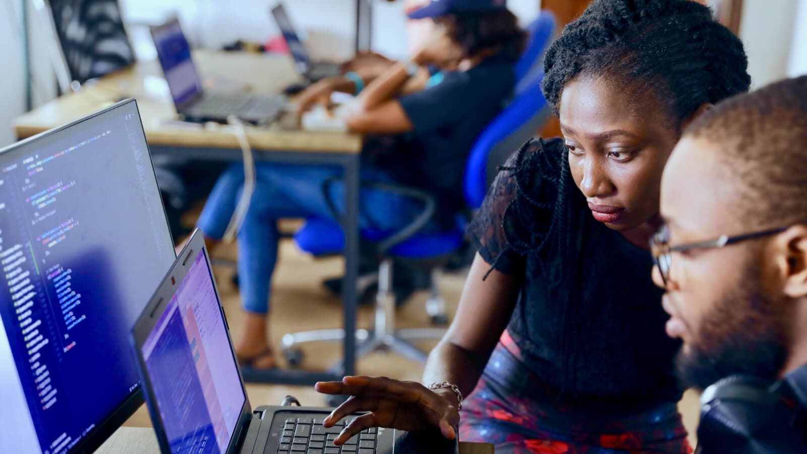 woman helping man on computer