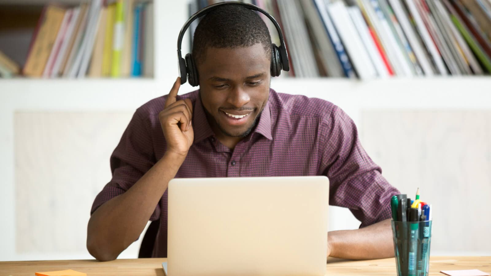 Man looking at laptop and listening to headphones