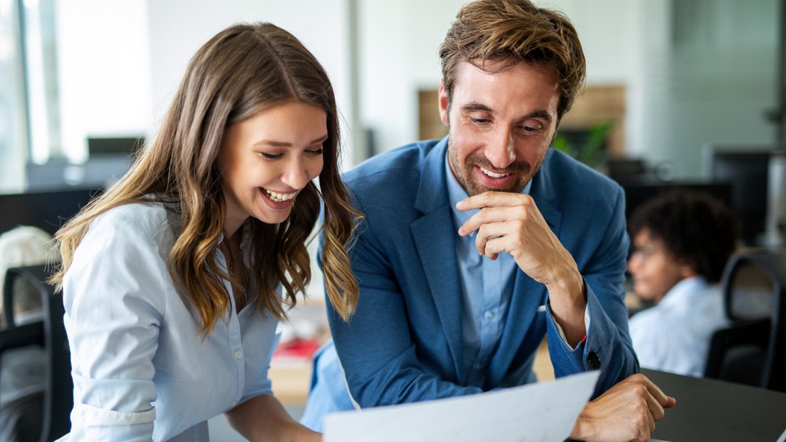 Man and woman looking happily at a sheet of paper