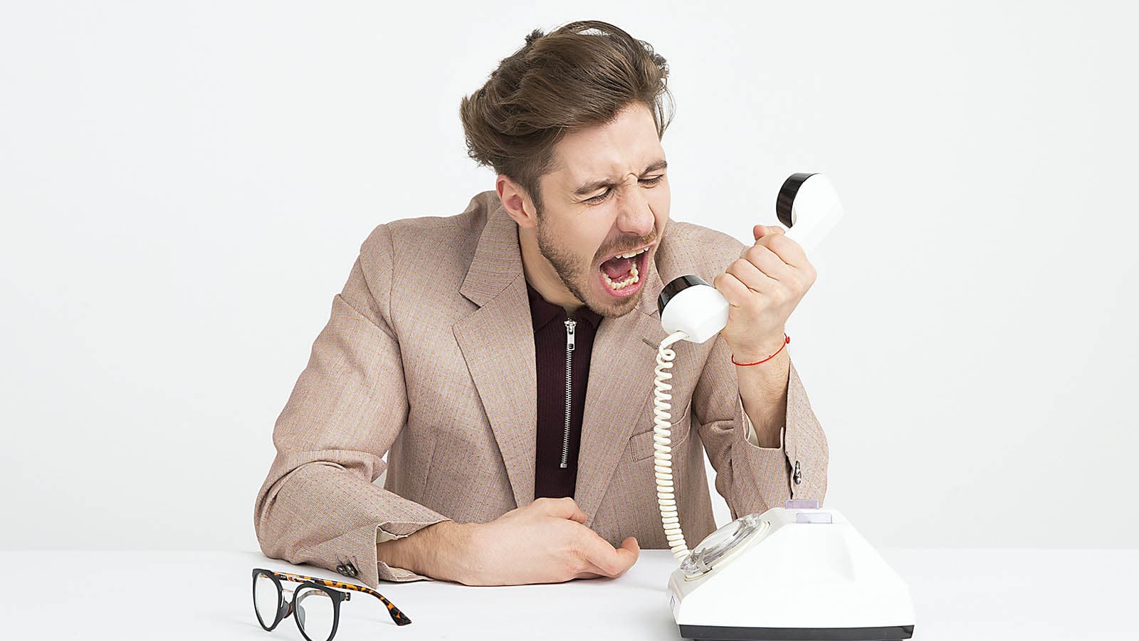 Man yelling into old-fashioned telephone
