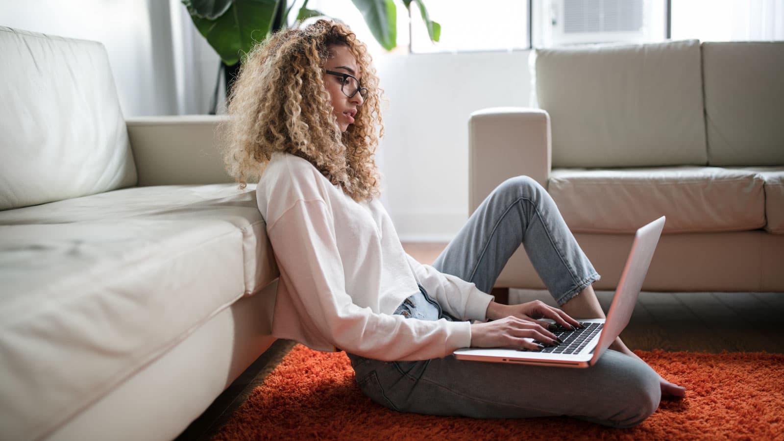 Woman sitting on the floor with a laptop on her lap